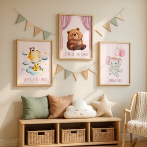 Può includere: Tre stampe artistiche incorniciate per la cameretta con illustrazioni di animali e citazioni motivazionali. Le stampe sono in cornici di legno e sono esposte sopra una panca di legno con cuscini e cesti. Una ghirlanda di bandiere triangolari è appesa sopra.