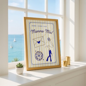 May include: A framed print with the words "Mamma Mia!" in a whimsical font, set against a cream and yellow striped background. The print features blue illustrations of a disco ball, envelope, microphone, and a dancing figure. The frame is a light wood color.