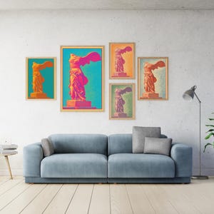 Puede incluir: Una colección de impresiones artísticas enmarcadas que presentan una estatua estilizada de Niké, la diosa griega de la victoria. Las impresiones muestran la estatua en vibrantes tonos naranja, rosa y morado sobre fondos coloridos. La obra de arte se exhibe sobre un sofá azul.