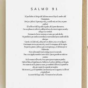 Puede incluir: Una tarjeta impresa con el texto "SALMO 91" en la parte superior, seguido de un pasaje en español. La tarjeta es blanca con texto negro, dentro de un marco de cartulina marrón. El texto es un pasaje religioso.