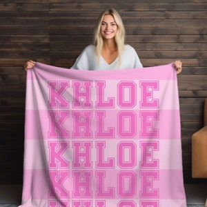 Könnte beinhalten: Rosa-weiße gestreifte Fleece-Decke mit dem Namen "Khloe", der in großer, fetter Schrift wiederholt wird.