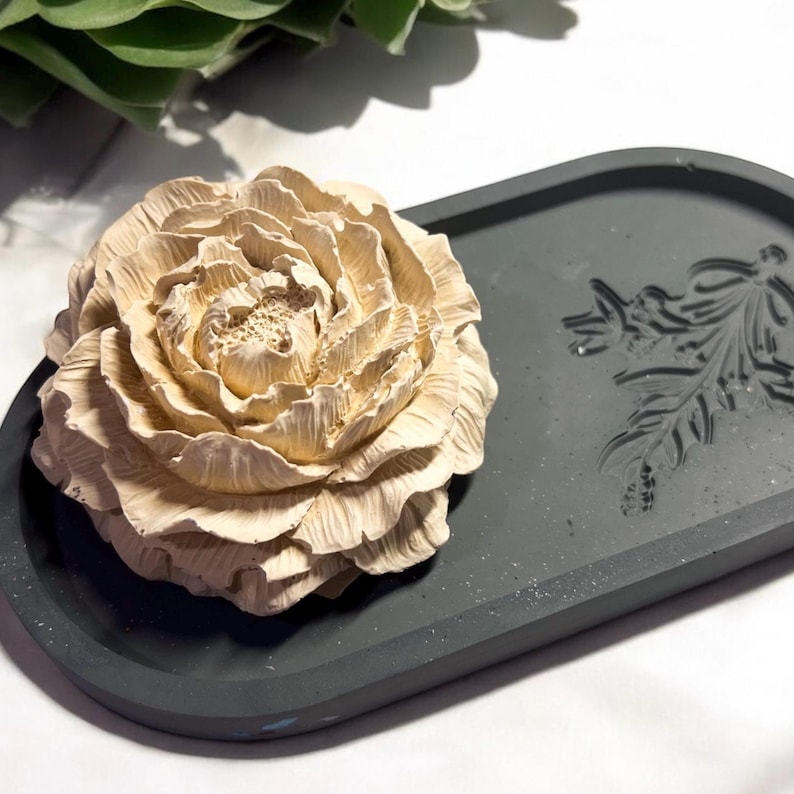 A latte colored aromatherapy home fragrance aroma Stone that is sitting on a charcoal gray tray in a cottage core decorated entryway