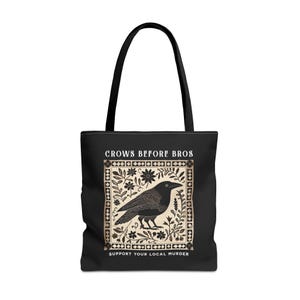 Peut inclure: Sac fourre-tout noir avec un motif blanc représentant un corbeau dans un cadre floral. Le texte "Crows Before Bros" et "Support Your Local Murder" est imprimé sur le sac.