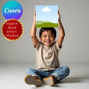 May include: A young child sits smiling, holding a square mockup above their head. The mockup features a blue sky with a white cloud and green hills. The image also includes the Canva logo and text: "Square Book Smart Mockup."