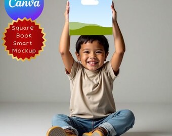 Può includere: Un bambino sorridente è seduto, tenendo un mockup quadrato sopra la sua testa. Il mockup presenta un cielo blu con una nuvola bianca e colline verdi. L'immagine include anche il logo Canva e il testo: "Square Book Smart Mockup."