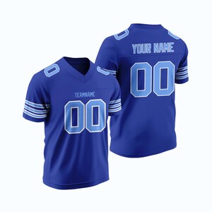 Puede incluir: Dos camisetas de fútbol azul real con detalles en blanco y azul claro. La camiseta de la izquierda tiene el texto "TEAMNAME" y el número "00" en la parte delantera. La camiseta de la derecha tiene el texto "YOUR NAME" y el número "00" en la parte posterior.