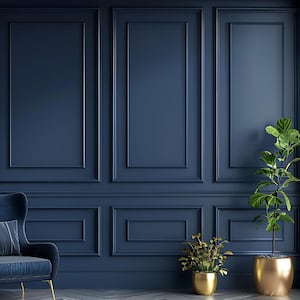 May include: A navy blue wall with rectangular paneling frames a blue velvet armchair with a matching cushion. Two potted plants with green leaves and gold pots flank the chair, with a third plant in a gold pot.