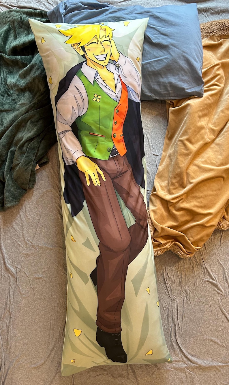 May include: A rectangular body pillow featuring a printed illustration of a smiling character with spiky yellow hair. The character wears a white collared shirt, a green and orange vest, brown trousers, and a dark jacket, set against a light background.