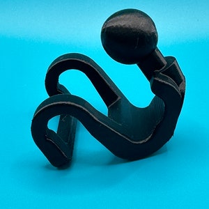 May include: A black 3D printed figurine of a person sitting with their head in their hands. The figurine is made of a smooth, matte black plastic.