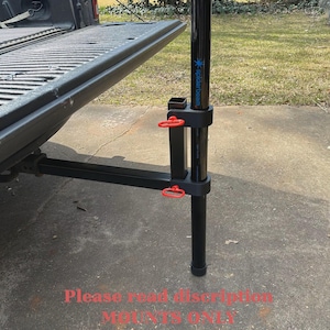 May include: Black metal truck bed mount with red handles, supporting a black pole with the text "spiderbeam". The mount is attached to the truck bed. The text "Please read description MOUNTS ONLY" is visible.