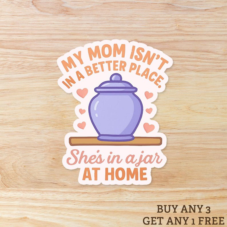 May include: A sticker with the text "MY MOM ISN'T IN A BETTER PLACE. She's in a jar AT HOME." The sticker features a purple jar with a lid, surrounded by small pink hearts, on a wooden shelf.