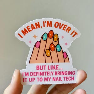 May include: A sticker with the text "I MEAN, I'M OVER IT" and "BUT LIKE... I'M DEFINITELY BRINGING IT UP TO MY NAIL TECH". The sticker features a cartoon illustration of a hand with colorful nail polish.