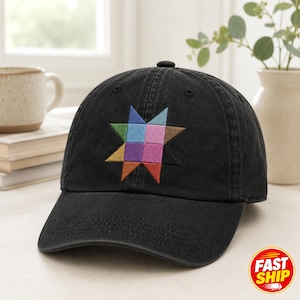 May include: A black baseball cap featuring an embroidered eight-pointed star design on the front. The star is composed of smaller squares in various colors, including blue, light blue, green, brown, purple, pink, orange, and red.
