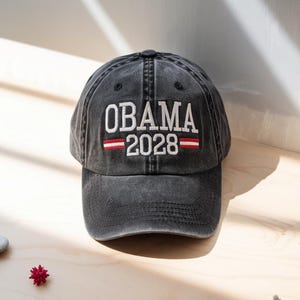 May include: A black baseball cap with the text "OBAMA 2028" embroidered in white with red stripes above and below the text.