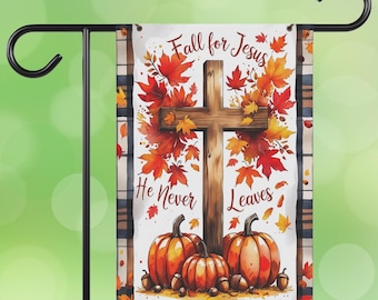 May include: A garden flag featuring a wooden cross, pumpkins, and autumn leaves. The flag reads "Fall for Jesus, He Never Leaves." The design includes a plaid pattern and is displayed on a black metal garden stake.