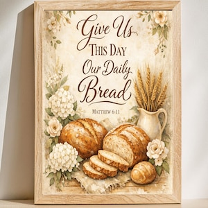 Op de afbeelding: Een ingelijste print met de tekst "Give Us This Day Our Daily Bread" uit Mattheüs 6:11. De afbeelding toont brood, tarwe en bloemen in een vintage stijl, met een lichtbruine houten lijst.