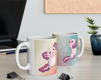 May include: Two white ceramic mugs with colourful designs featuring cartoon axolotls. One mug has a pink axolotl with purple fins and the other has a pink axolotl with red fins. Both mugs have a gradient background with white bubbles.