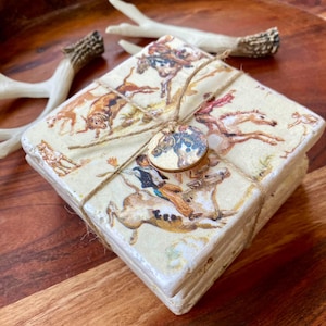 May include: Set of four square coasters with a vintage illustration of horses and riders. The coasters are tied together with twine and a wooden tag.