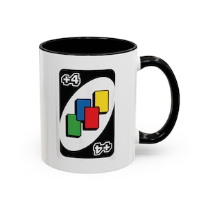 May include: White ceramic mug with a black interior and handle. The mug features a large graphic of a +4 Uno card, with green, blue, red, and yellow squares. A fun gift for game lovers.