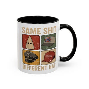 Op de afbeelding: Witte keramische mok met een zwarte binnenkant en handvat. De mok heeft de tekst "SAME SHIT DIFFERENT HAT" met afbeeldingen van een KKK-kap, een Confederate vlag hoed, een Nazi hoed en een "Make America Great Again" hoed.