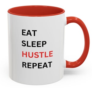 May include: White ceramic mug with a red interior and handle. The mug features the words "EAT SLEEP HUSTLE REPEAT" in black and red block letters. The mug is designed for hot beverages.
