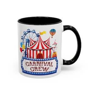 Puede incluir: Taza de cerámica blanca con interior y asa negros. La taza presenta una colorida escena de carnaval con una noria, tiendas de campaña y un globo aerostático. El texto "CARNIVAL CREW" se muestra en un letrero azul.