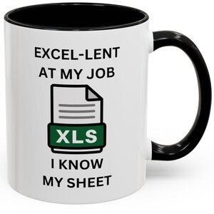 Puede incluir: Taza de café de cerámica blanca con borde y asa negros. La taza tiene un gráfico negro y verde de un archivo con el texto "XLS" en él. El texto en la taza dice "EXCEL-LENT AT MY JOB I KNOW MY SHEET".