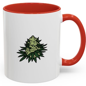 Puede incluir: Taza de cerámica blanca con borde y asa rojos. La taza presenta una ilustración verde y blanca de un brote de marihuana.