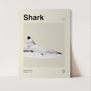 May include: A poster with the word "Shark" in bold black letters at the top. A grayscale image of a shark is centered on the poster. The text "Keep Attacking Habitat / Ocean" is at the bottom. A globe icon is in the lower right corner.