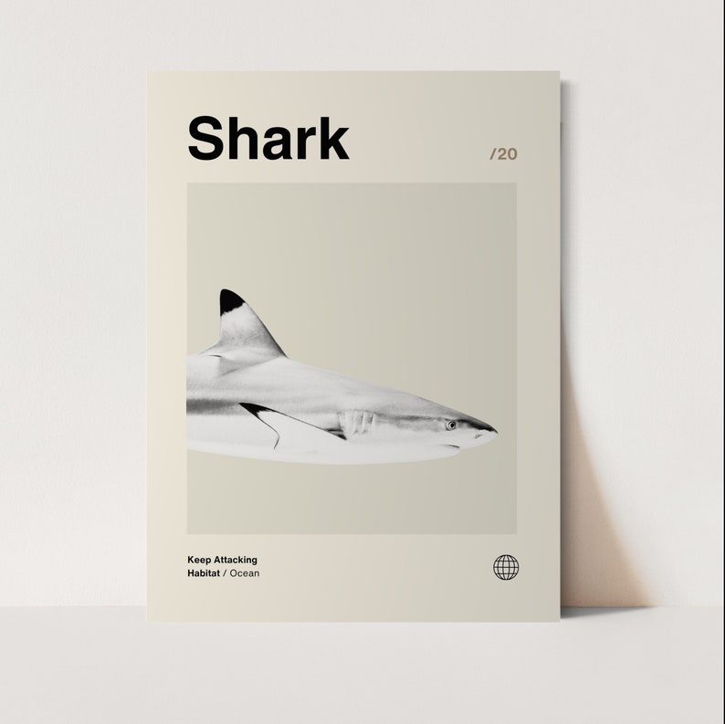 May include: A poster with the word "Shark" in bold black letters at the top. A grayscale image of a shark is centered on the poster. The text "Keep Attacking Habitat / Ocean" is at the bottom. A globe icon is in the lower right corner.