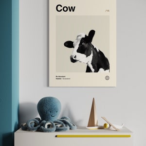 May include: A black and white cow with a beige background. The poster has the word "Cow" in bold black text at the top and the text "Be Abundant" and "Habitat/Grassland" at the bottom. The poster also has the number "1/14" in the top right corner.