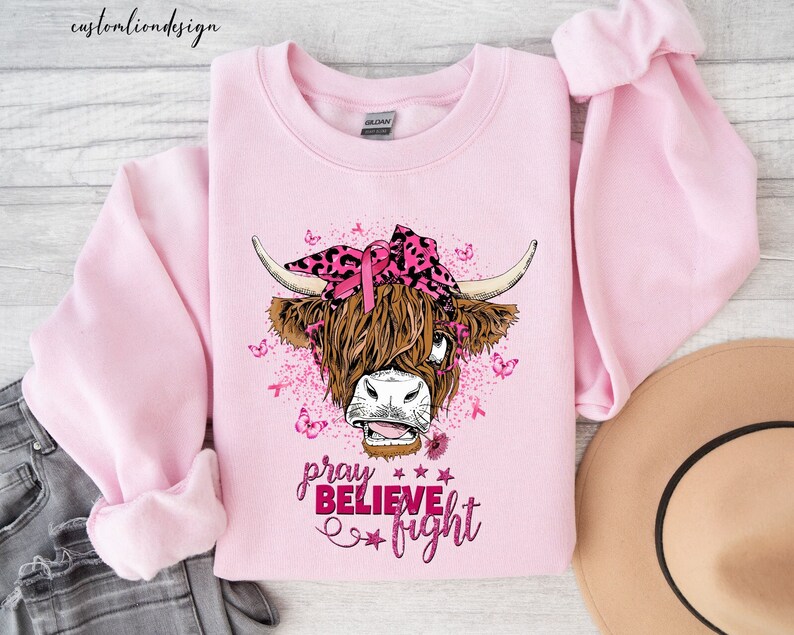 a pink shirt with a cow wearing a pink bow