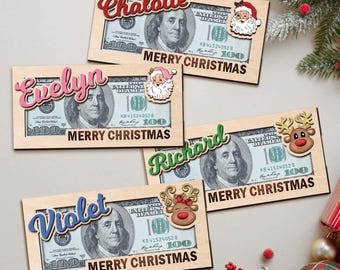 Könnte beinhalten: Vier Weihnachts-Geschenkkartenhalter aus Holz, jeweils mit einem 100-Dollar-Schein-Design. Die Halter tragen Namen wie "Chalotte", "Evelyn", "Richard" und "Violet" mit dem Text "Merry Christmas".