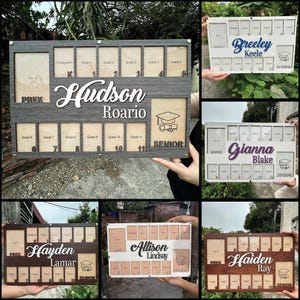 May include: Wooden graduation photo display with spaces for photos from Pre-K to Senior year. The display features the name "Hudson Roario" in a decorative font, along with a graduation cap graphic.