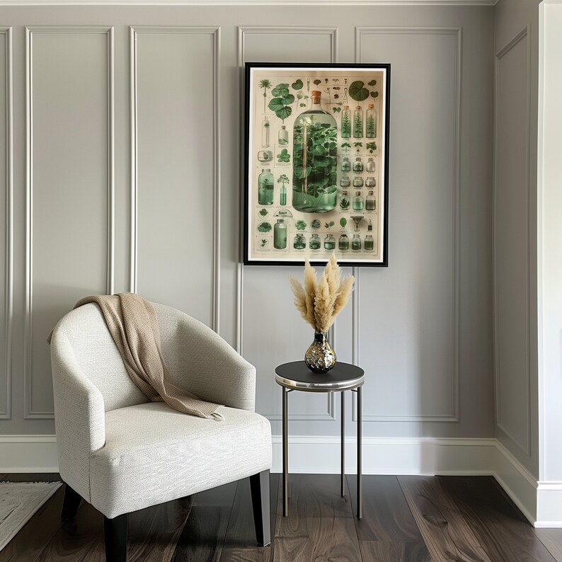 May include: A white armchair with a beige throw blanket sits next to a black side table with a vase of dried pampas grass. A framed botanical illustration of plants in glass bottles hangs on the wall behind the table.