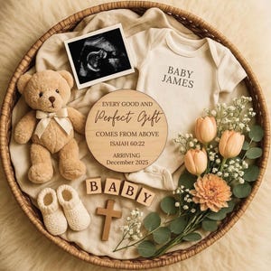 May include: A baby announcement arrangement in a woven basket. It includes a teddy bear, baby booties, a onesie with "BABY JAMES" printed on it, a wooden sign, and a sonogram image. The sign reads "EVERY GOOD AND PERFECT GIFT COMES FROM ABOVE ISAIAH 60:22 ARRIVING December 2025".