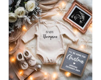 Könnte beinhalten: Cremefarbener Baby-Body mit dem Text "BABY Thompson". Das Bild zeigt Babyschuhe, einen gerahmten Ultraschall und eine Buchstaben-Tafel mit "I'll be home for Christmas arriving December 2025". Festliche Dekoration.