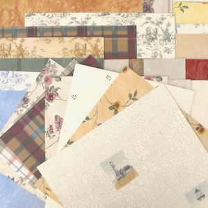 May include: A collection of wallpaper samples with various patterns and colors. Designs include floral, plaid, toile, and textured patterns. The samples are arranged in a fan shape, showcasing the variety of styles available.