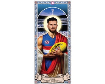 May include: A religious-themed print featuring a portrait of Marcus Bontempelli, an Australian Rules Football player, holding a football. He is wearing a red, white, and blue jersey with the words "AFL" on the front. The print has a gold frame and a blue background with a stadium in the background.