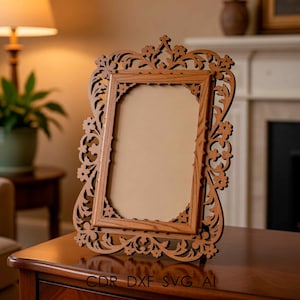 May include: An intricately carved wooden picture frame with floral and scroll patterns. The frame is made of light brown wood and has a rectangular aperture for a photograph. The frame is on a wooden surface. The text "CDR DXF SVG AI" is at the bottom.