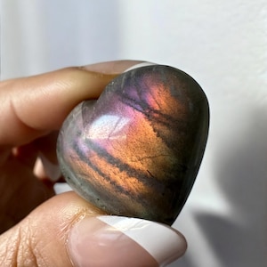 May include: A heart-shaped labradorite crystal with iridescent purple, blue, and orange hues.