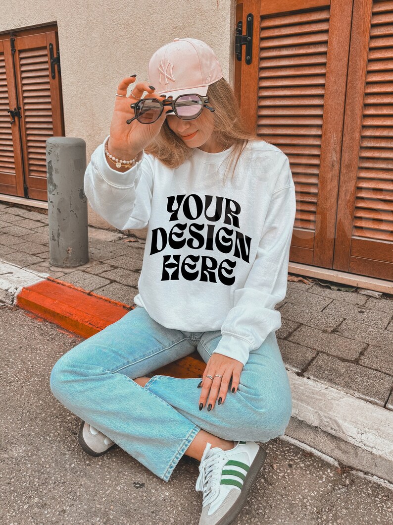 White gildan 18000 mockup white sweatshirt mockup Oversized blank white sweatshirt gildan g180 model mockup, Trendy outdoors lifestyle mock image 1