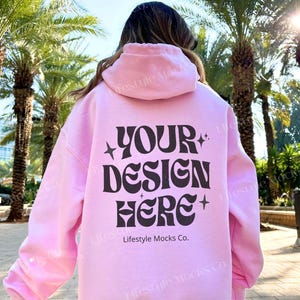 May include: A pink hoodie with a black graphic that says "YOUR DESIGN HERE" and "Lifestyle Mocks Co."