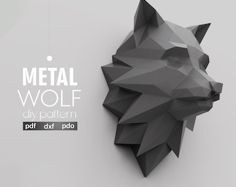May include: A geometric, dark gray metal wolf head sculpture. The image features the text "METAL WOLF diy pattern" with file format options. The wolf head is a low-poly design, with sharp angles and a modern aesthetic. The artaxis studio logo is in the bottom right.