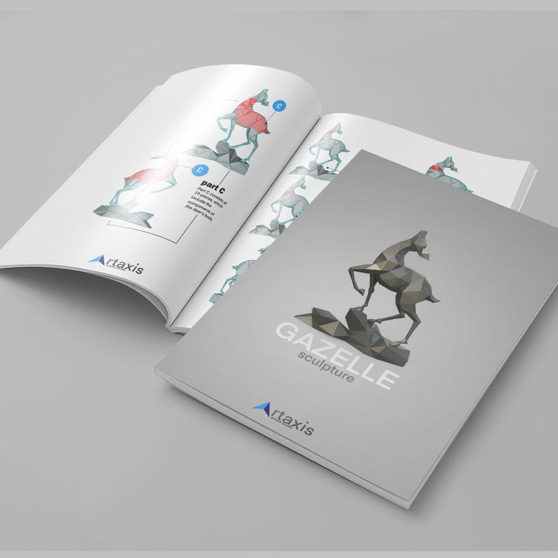 May include: Open book and brochure with a gazelle sculpture design. The brochure cover features a geometric gazelle sculpture on a rock formation, with the text "GAZELLE sculpture" and the Artaxis logo. The open book shows assembly instructions.