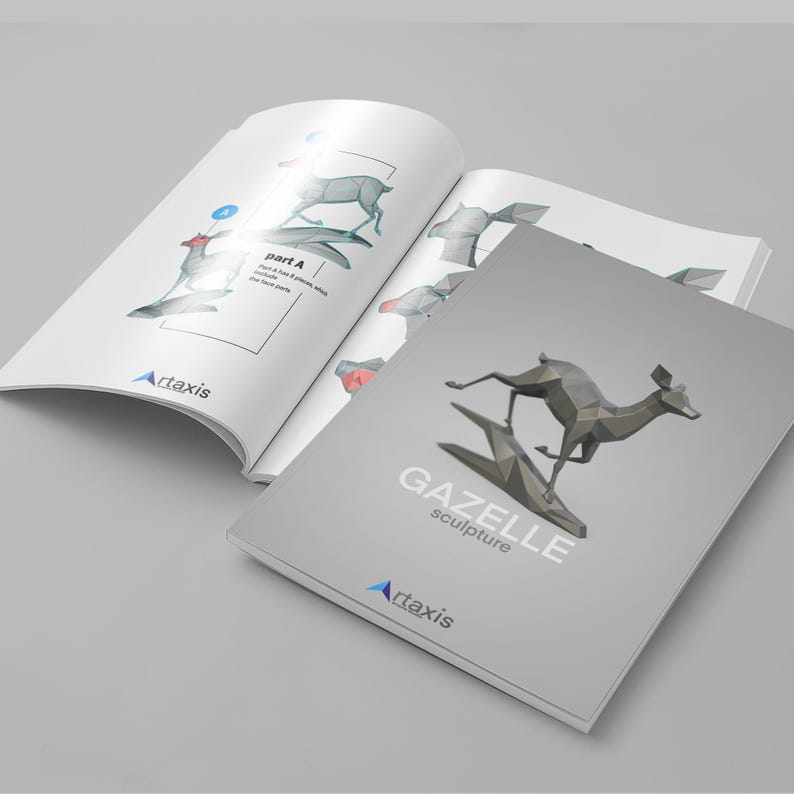 May include: A grey papercraft gazelle sculpture kit with instructions. The cover of the booklet shows a finished sculpture of a gazelle running. The booklet is titled "GAZELLE sculpture" and has the logo "Artaxis" on the cover.