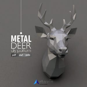 May include: A geometric, metallic deer head sculpture in shades of grey, mounted on a grey wall. The image includes the text "METAL DEER diy pattern" with file format options: pdf, dxf, and pdo. The artaxis studio logo is at the bottom.