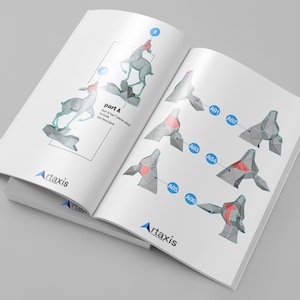 May include: Open book with instructions for assembling a geometric deer sculpture. The instructions show the deer in stages, with labels and diagrams. The "Artaxis" logo is visible on the pages.