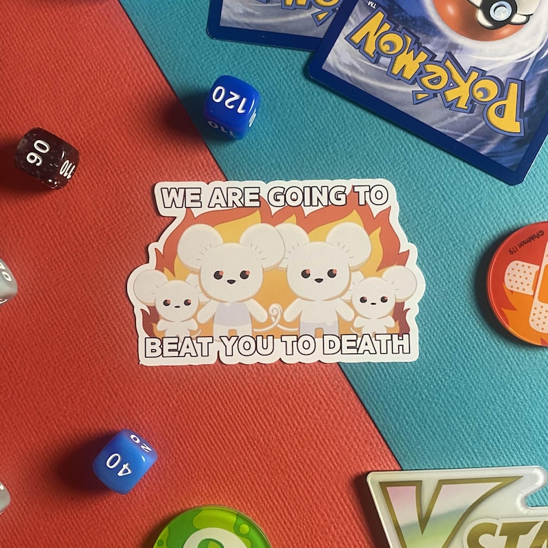 Pu&ograve; includere: Un adesivo bianco con quattro topi dei cartoni animati davanti alle fiamme, con la scritta "WE ARE GOING TO BEAT YOU TO DEATH". L'adesivo &egrave; su uno sfondo rosso e blu, con dadi e una carta Pok&eacute;mon.
