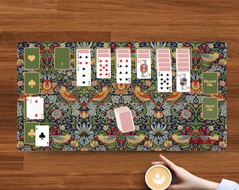 May include: A rectangular play mat featuring a dark blue background with a colourful floral and bird pattern, displaying a digital solitaire card game layout with various playing cards, a discard pile, a stock pile, and the word Solitaire.